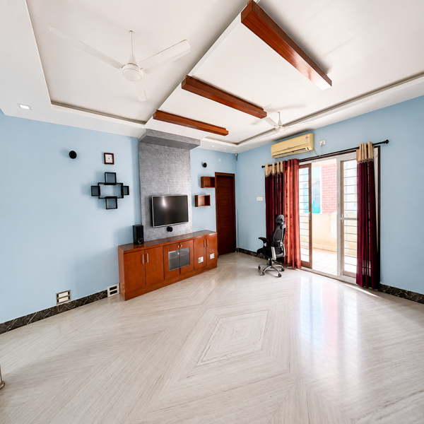 spacious living room, modern living area, bright living room, contemporary home interior, elegant lounge, large sitting room, open floor plan, marble flooring, polished marble floor, blue accent walls, pastel blue interior, wooden TV unit, wall mounted television, entertainment center, media console, decorative wall panel, textured feature wall, floating shelves, wooden cabinetry, sliding glass doors, balcony access, large windows, natural daylight, window curtains, air conditioned room, ceiling fan, false ceiling, wooden ceiling accents, recessed lighting, home office corner, office chair, work from home space, study area, spacious family room, furnished apartment, premium residence, comfortable lounge space, urban home interior, residential property, rental home, student accommodation, students, business professionals, working professionals, corporate accommodation, executive living, bachelor accommodation, family accommodation, modern rental property, move in ready home, comfortable living space.